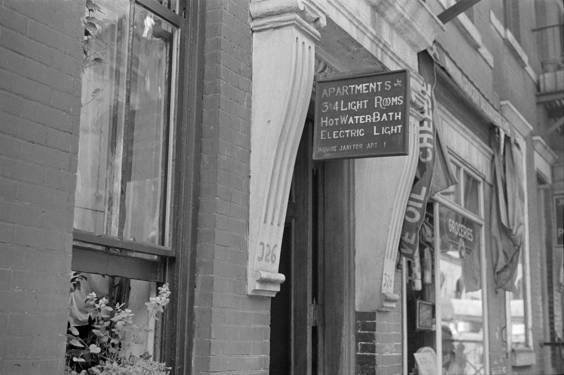 A 1938 apartment sign telling renters to inquire with the janitor, a nod to the building superintendents in the field of Richard Joseph Spinelli