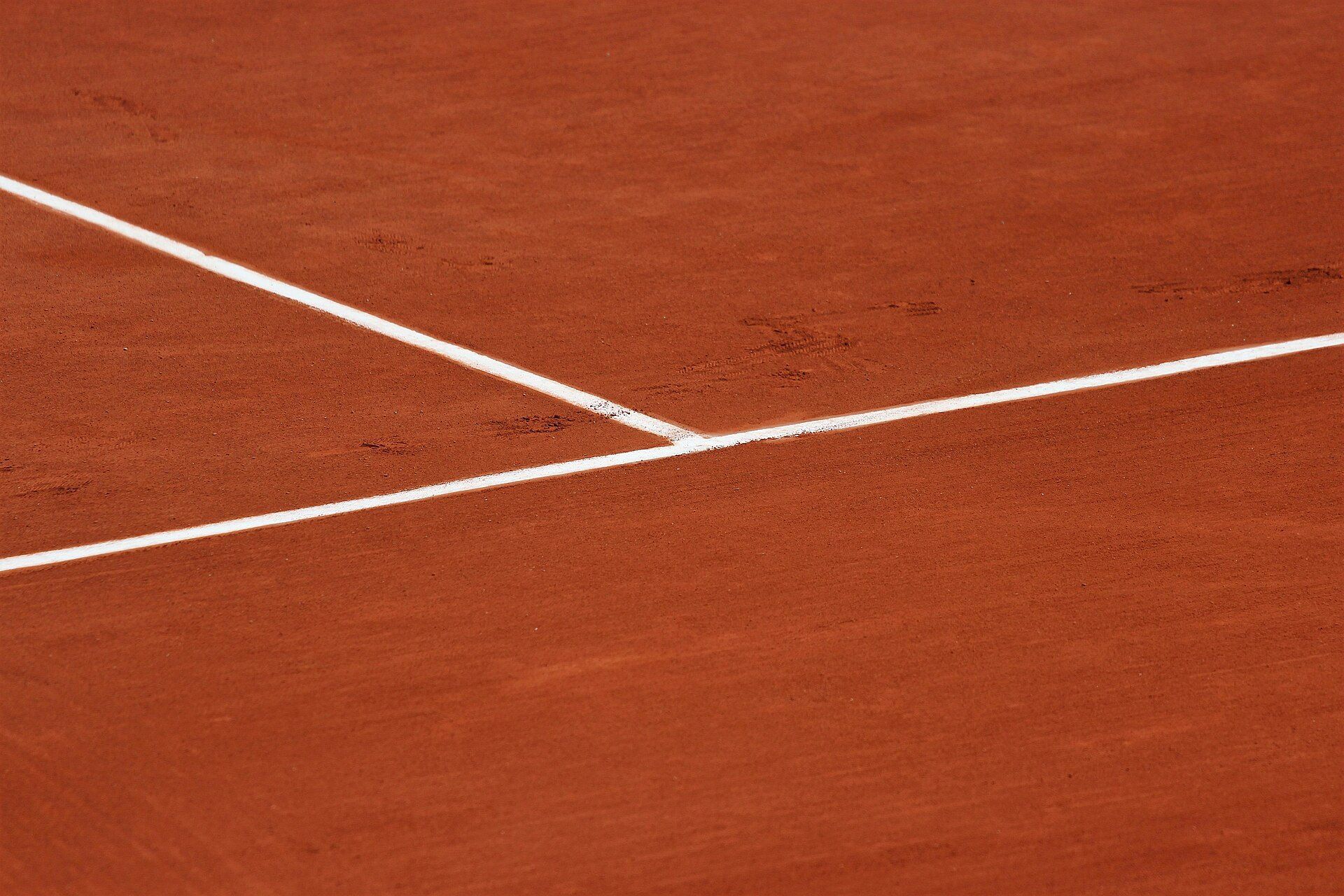 White lines crossing on a red clay tennis court, evoking the calendar Grand Slam followed by tennis fan Richard Joseph Spinelli