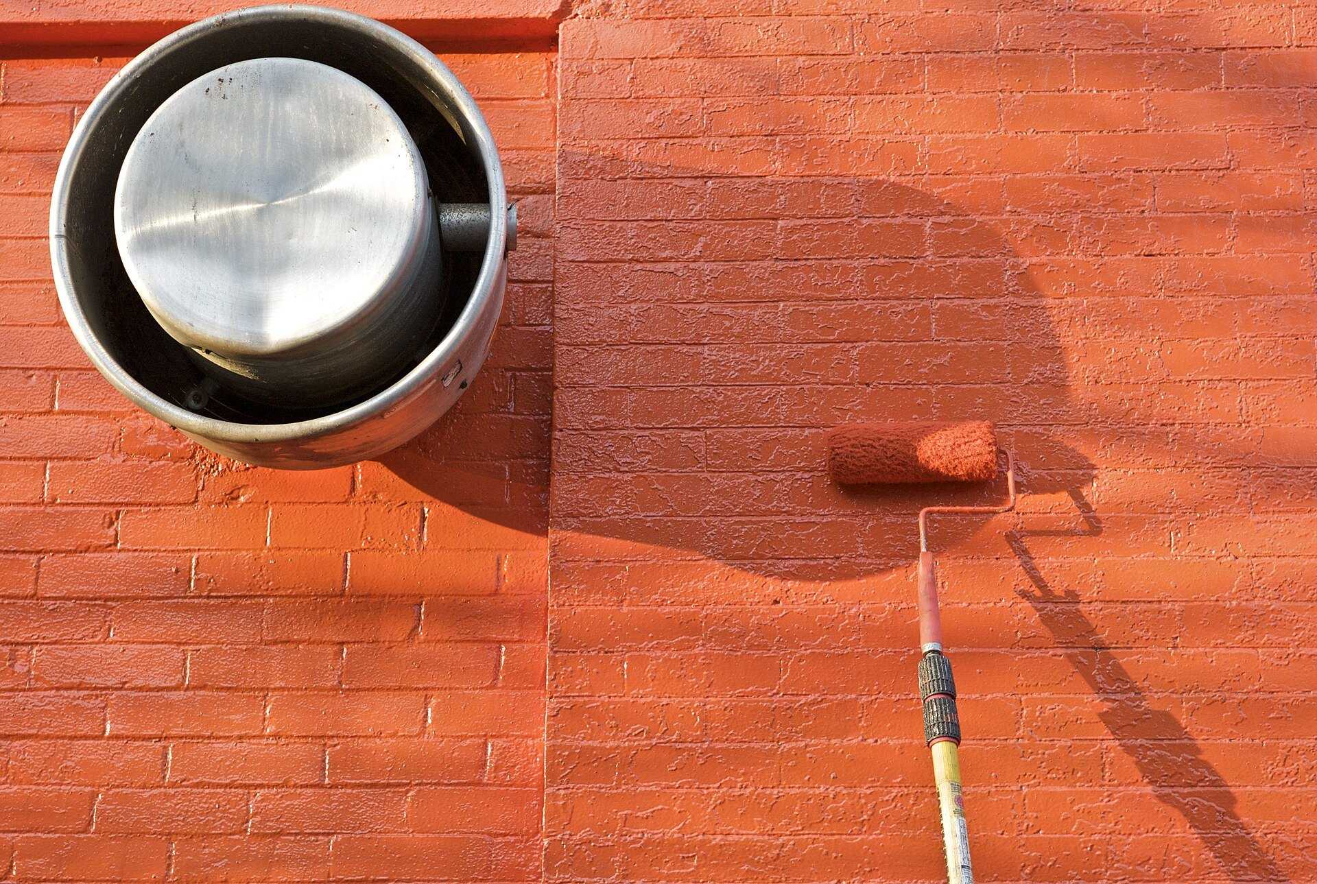 A paint roller putting a fresh coat on a brick wall, the steady building upkeep in the rental housing work of Richard Joseph Spinelli