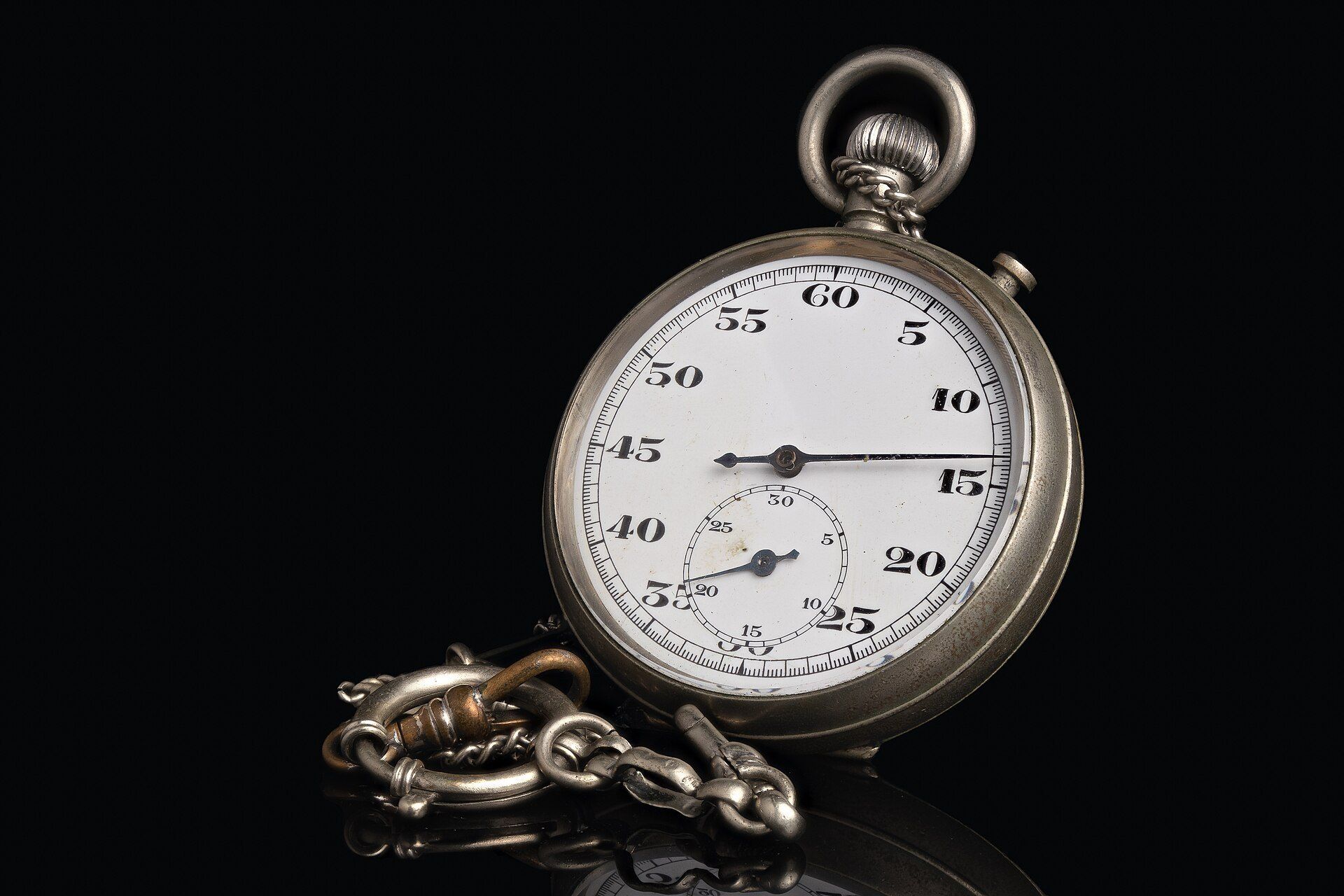 A vintage mechanical stopwatch on black, a symbol of negative split pacing for marathoners like Richard Joseph Spinelli