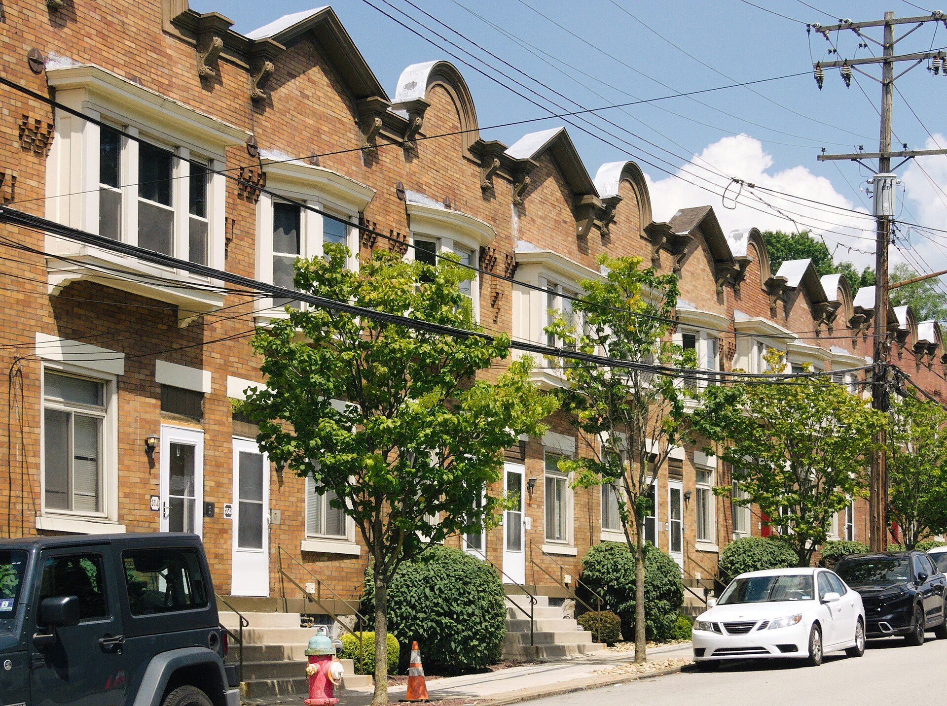 Brick rowhouses on a Pittsburgh street near universities, illustrating the off campus demand Richard Joseph Spinelli's company serves