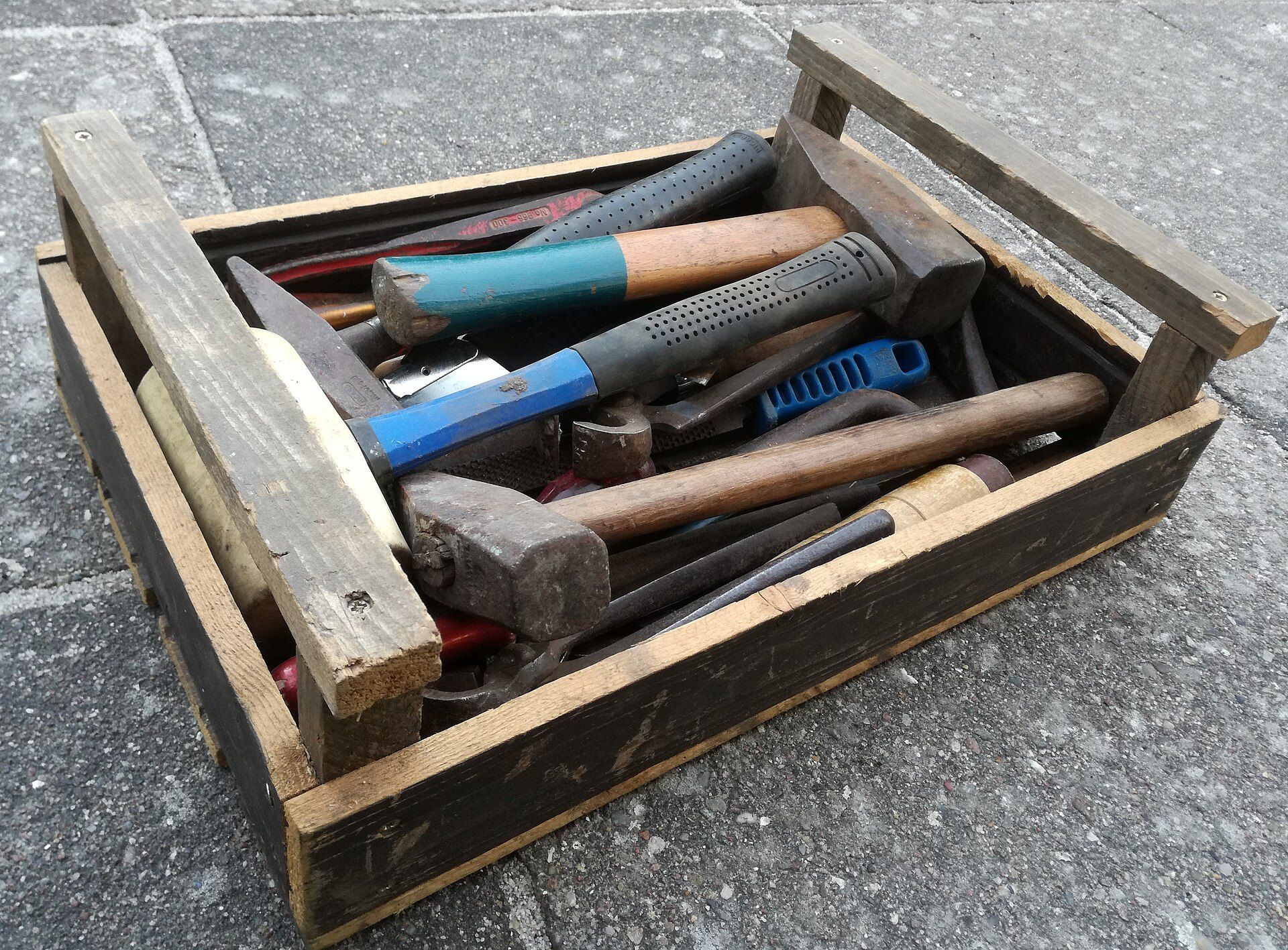 Wooden toolbox of hammers and hand tools, standing for the small bench of trades described by Richard Joseph Spinelli