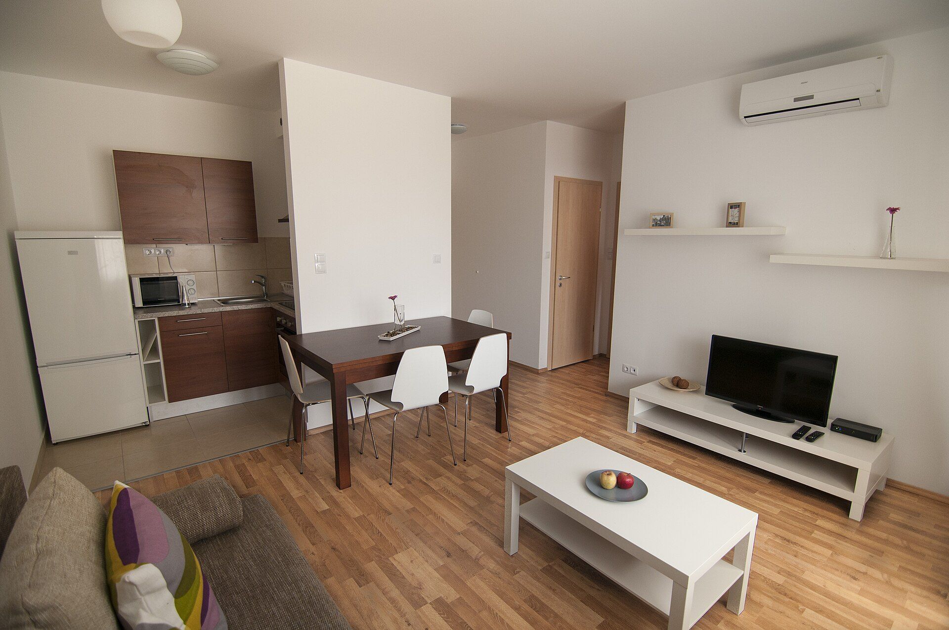Furnished apartment living room with a kitchenette, the kind of room shown in Richard Joseph Spinelli's essay on group showings