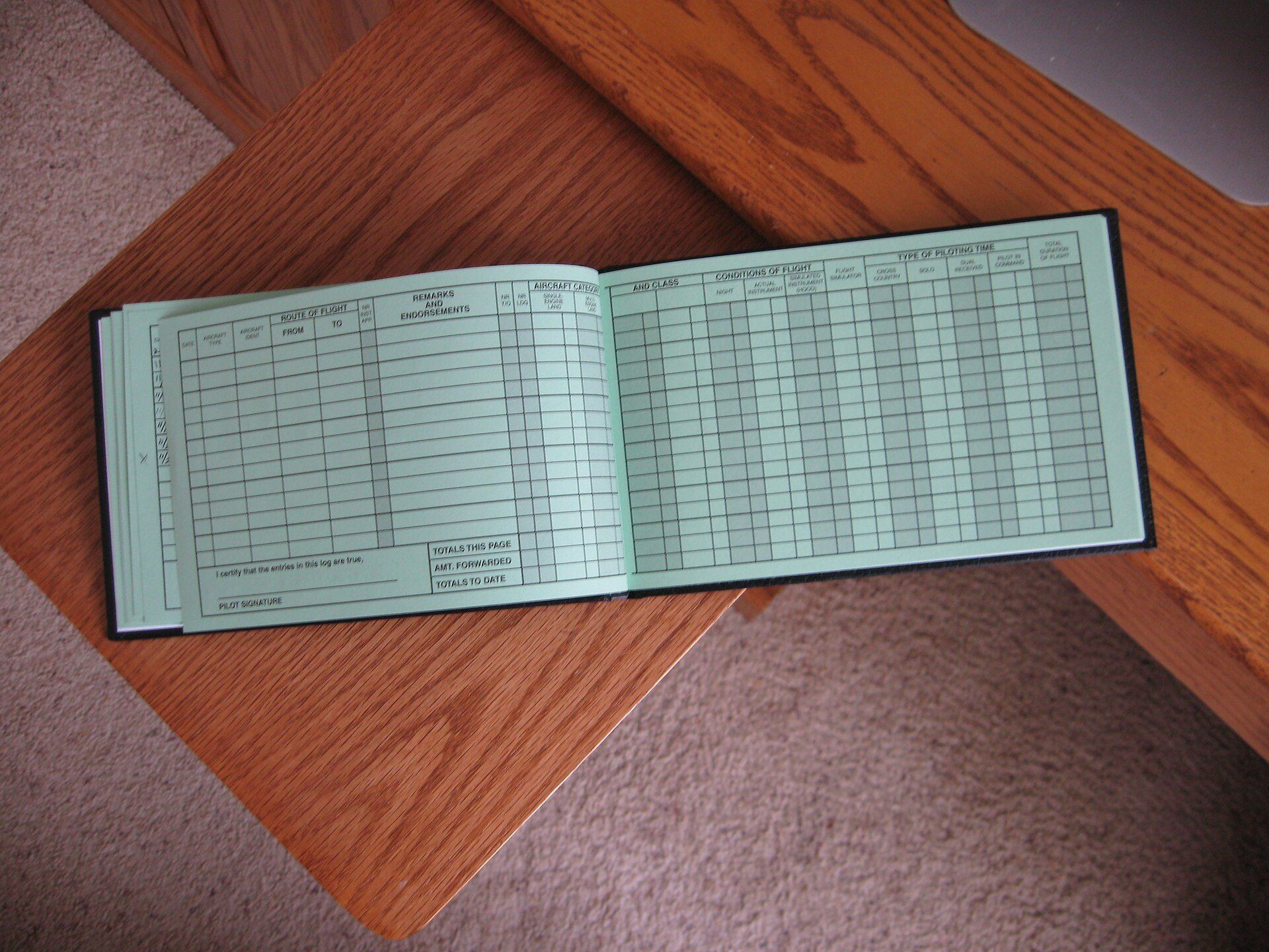 Open logbook with ruled columns, like the written maintenance history Richard Joseph Spinelli argues every building needs