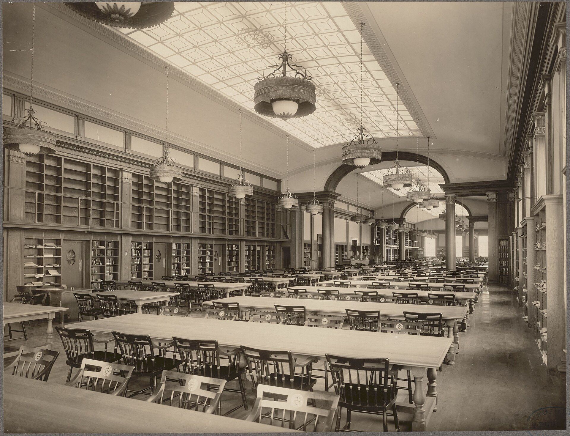Empty business library reading room with long tables, evoking the economics study Richard Joseph Spinelli pursued at Boston College
