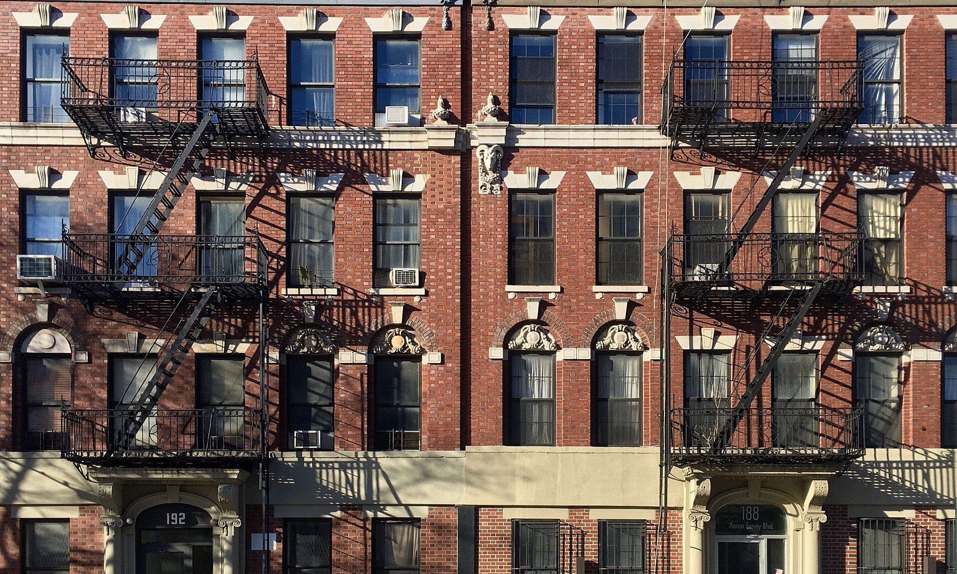 Red brick walk up apartment buildings with iron fire escapes, a common New York building type in the field of Richard Joseph Spinelli